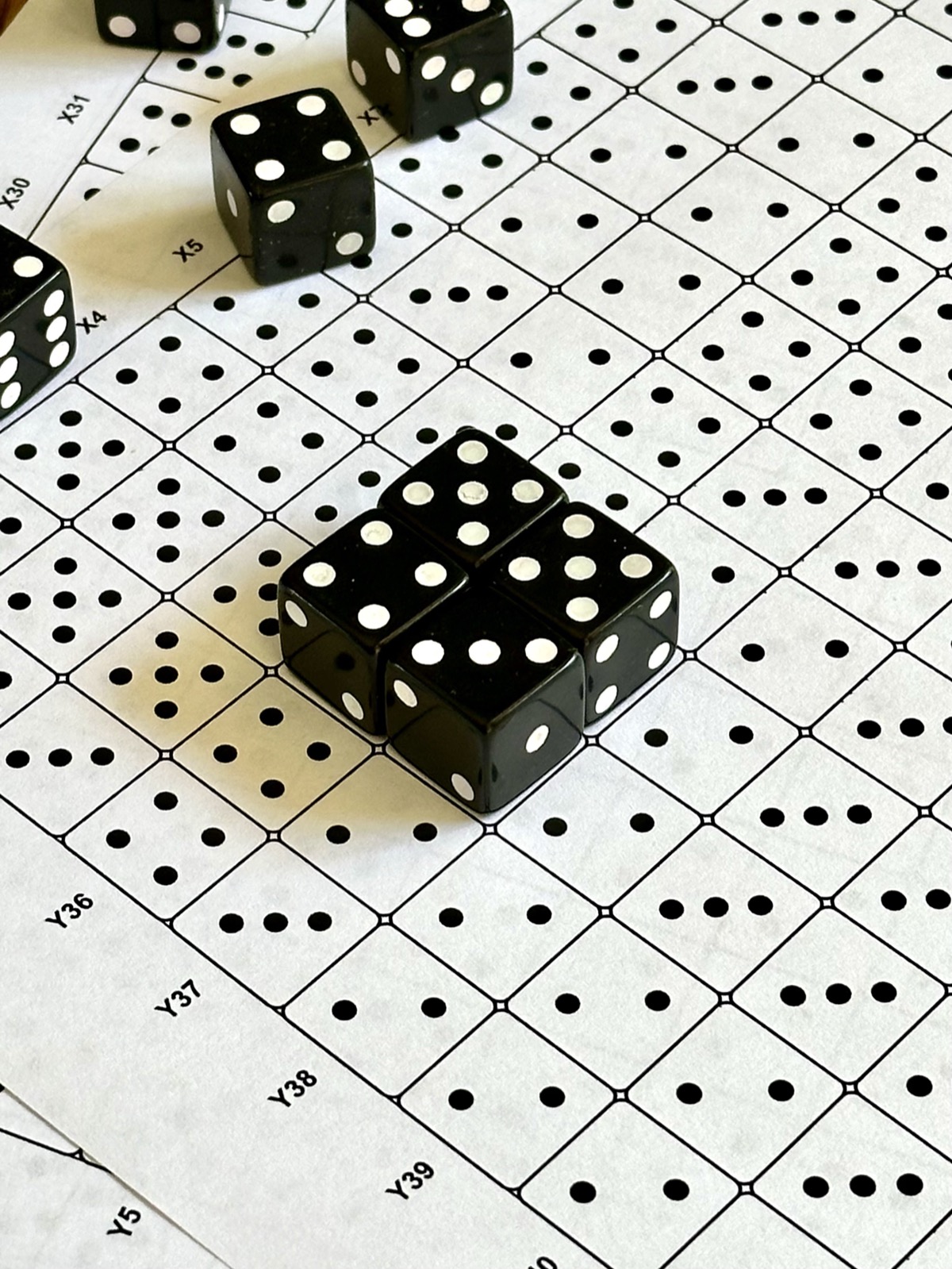Real dice placed on the printed grid following the printed pips